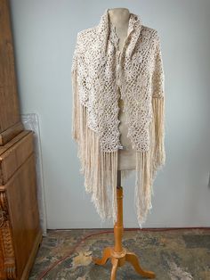 a white crocheted shawl sitting on top of a mannequin