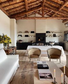 a living room filled with furniture and a fire place next to a table covered in candles