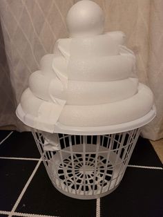 a white basket sitting on top of a tiled floor