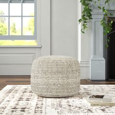 a white ottoman sitting on top of a rug