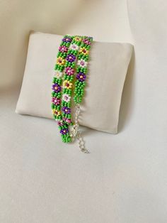 the bracelet is made with beads and glass beads, which are attached to a white pillow