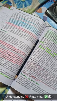 an open book sitting on top of a table next to a cup and pen with writing on it