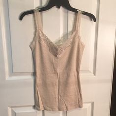 Cotton Camisole From The Express Never Worn And Still Has Tags On It V-Neck With Lace Straps And Neckline Length From Top Of Strap To Bottom: 24 Inches Width From Arm Pit To Arm Pit: 13 Inches Beige Spaghetti Strap Top With Lace Trim, Beige Lace Trim Cami Top, Affordable V-neck Cotton Camisole, Fitted Lace Trim V-neck Tank Top, Beige Fitted V-neck Tank Top, Beige V-neck Camisole With Built-in Bra, Beige V-neck Vest Top, Beige V-neck Fitted Camisole, Fitted V-neck Camisole With Contrast Lace