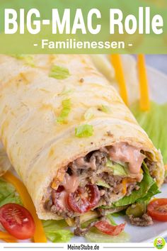 a close up of a burrito on a plate with lettuce and tomatoes