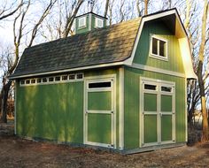 a small green building with a steeple on the top and two windows at the bottom