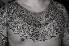 black and white photograph of a man's chest with intricate lace on his body