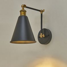 a black and gold wall light hanging from the side of a white wall in a room