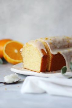 a slice of cake with icing and oranges around it on a white plate