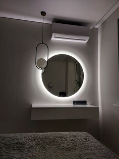 a round mirror hanging on the wall above a bed