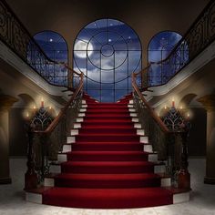 a red carpeted staircase leading up to a large window