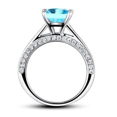 an engagement ring with a blue topazte and white diamonds on the sides, set in