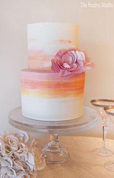 a white and pink cake sitting on top of a table