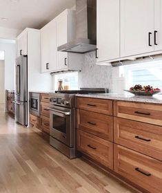 a kitchen with white cabinets and stainless steel appliances