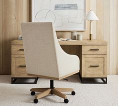 an office chair sitting in front of a desk with drawers and a lamp on it