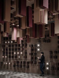 a man standing in front of a wall with lots of lights on top of it