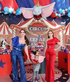 two women and a child are standing in front of a circus stage with clowns