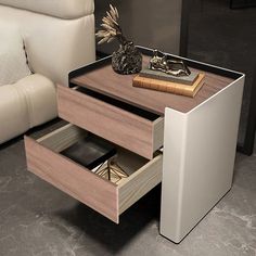 a table with two drawers on top of it next to a white couch and chair