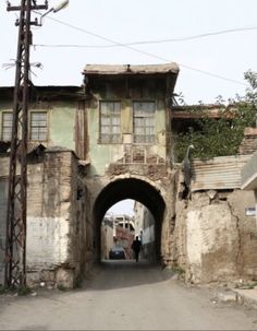 an old building with two people walking down the street