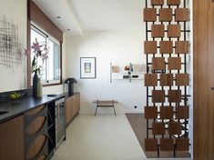 the interior of a modern home with wood and metal accents on the wall, along with an entry way that leads to another room