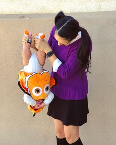 a woman is holding a small child dressed as a nemo