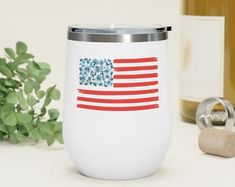 a wine glass with an american flag on it next to a bottle and corkscrew