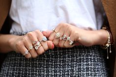 a woman holding her hands together with four rings on each hand and one ring in the other