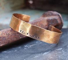 "Our bronze cuff is hand forged from rich jewelers bronze. Your date of choice is stamped by hand on to your bracelet. Cuffs are hammered for texture and then aged in an organic solution to give a warm, rich patina. Bronze is the traditional gift for the 8th and 19th anniversary. *SIZING* The circumference of each cuff is the size in inches plus a 1.25\" to 1.5\" gap. To get the size measure the wrist and compare it to the total in inches of the cuff sizes. For example: Size small is 6.25\" with Gold Hammered Cuff Bracelet For Anniversary, Bronze Stamped Jewelry For Anniversary, Hammered Bangle Cuff Bracelet For Anniversary, Artisan Hammered Gold Cuff Bracelet, Adjustable Hammered Cuff Bracelet For Anniversary, Adjustable Brass Bracelets For Anniversary, Rustic Stamped Cuff Bracelet Gift, Hand Forged Gold Cuff Bracelet As Gift, Gold Hand Forged Bracelets For Anniversary