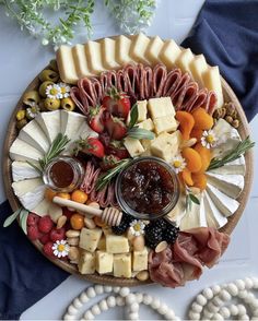 a platter filled with cheese, meats and fruit