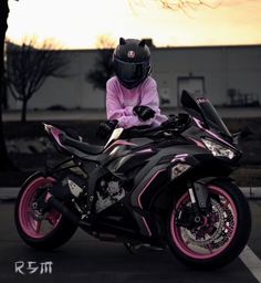 a person sitting on top of a pink motorcycle