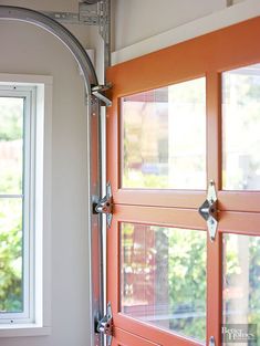 an orange door and window in a white room with red trim on the outside wall