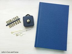 a blue binder, scissors and other items are sitting on a white table top