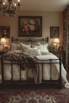 a bedroom with a bed, chandelier and pictures on the wall above it