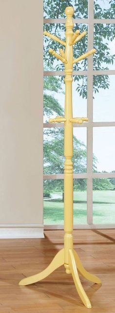 there is a yellow coat rack on the floor in front of an open window,