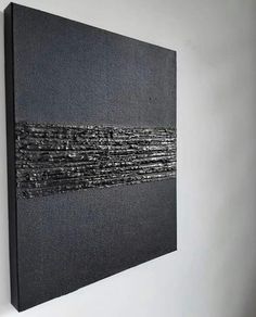 a black and white painting hanging on the wall