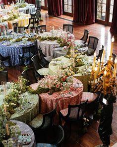 a room filled with tables and chairs covered in tablecloths