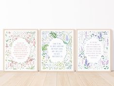 three framed art prints with flowers and words on the front, one in pink, one in blue