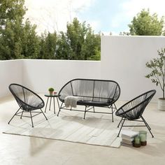 an outdoor patio with black furniture and plants