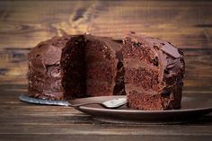 a piece of chocolate cake on a plate with a fork next to it and one slice missing