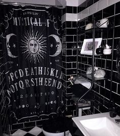 a black and white bathroom with a shower curtain that has the moon and stars on it