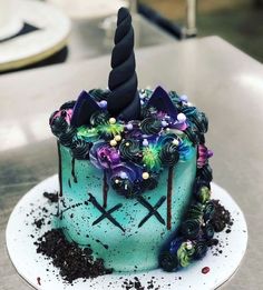 a blue cake with a unicorn horn on top