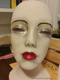 a white mannequin head with red lipstick on it's lips and eyes