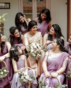 a group of bridesmaids in purple dresses posing for a photo with each other