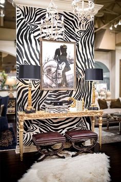 a zebra print wall in a living room with two chairs and a chandelier