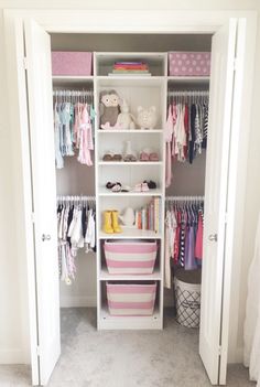 a white closet filled with lots of baby clothes and other items on top of shelves