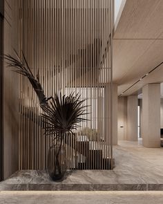 a plant in a vase sitting on the floor next to a wall with wooden slats