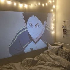 a bedroom with lights strung from the ceiling and an anime poster on the wall above it