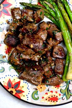 steak and asparagus on a colorful plate with floral design pattern, ready to be eaten