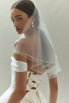 a woman in a wedding dress with a veil on her head