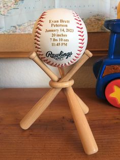 a baseball sitting on top of a wooden stand next to a toy truck and map