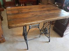 an old sewing table is sitting on the floor